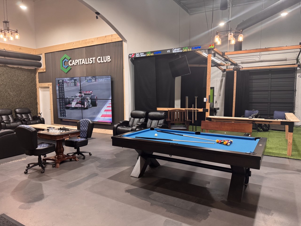 Capitalist Club lounge with a pool table, theater screen, and games